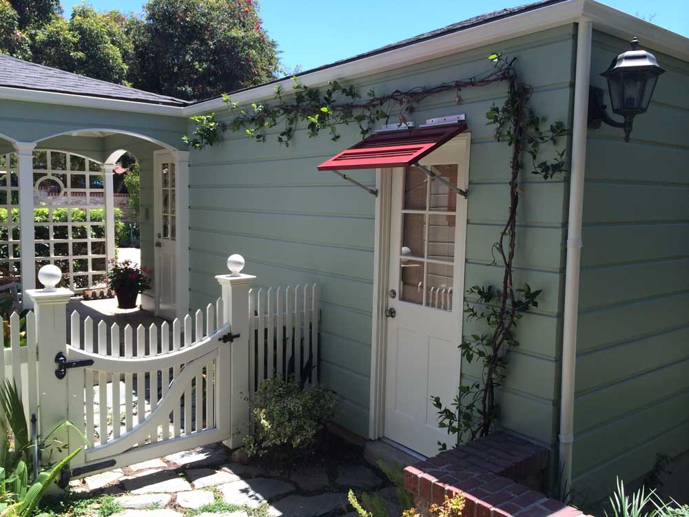 Awning bahama shutter with louvers above an exterior door.