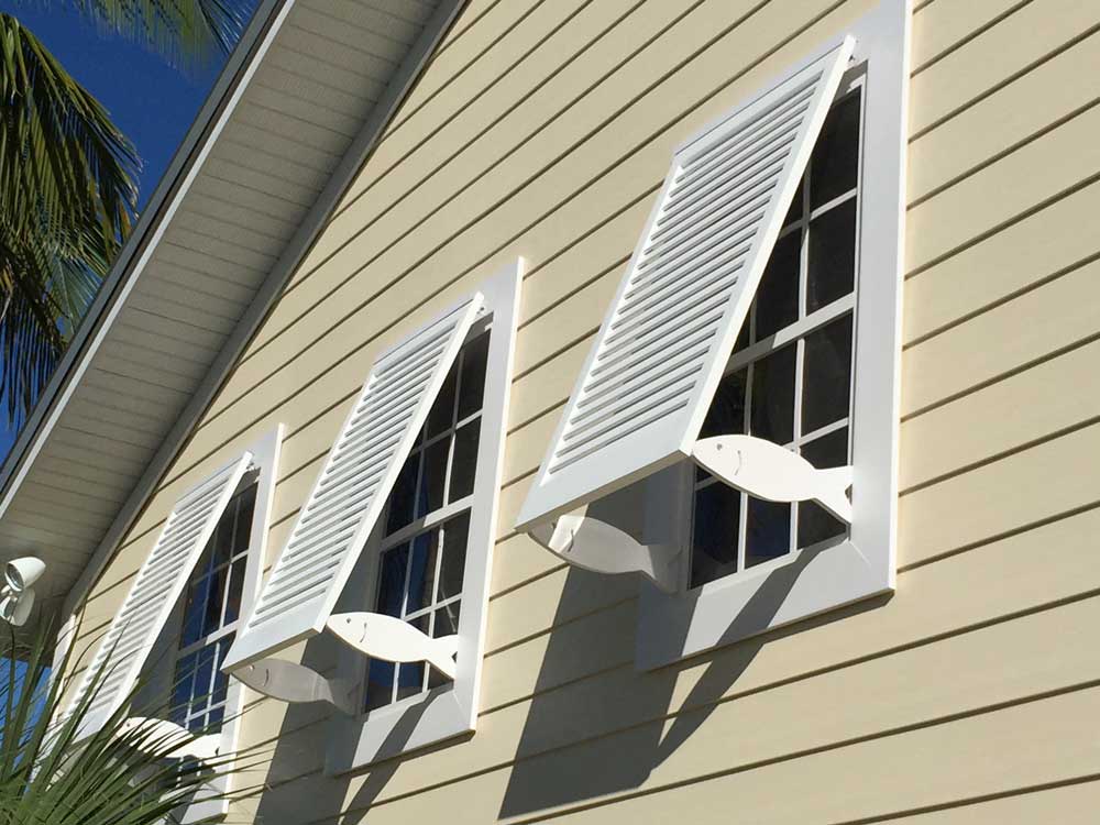 Fixed tropical exterior bahama shutters with cutout fish supports in Florida.