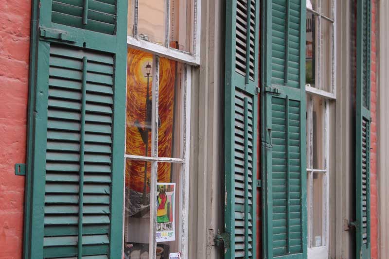 Green exterior New Orleans shutters on the street.