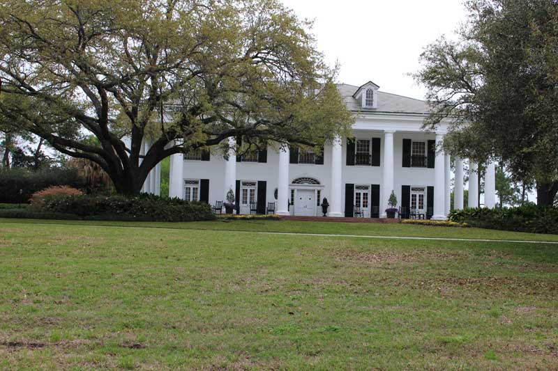 White plantation home with black New Orleans shutters.