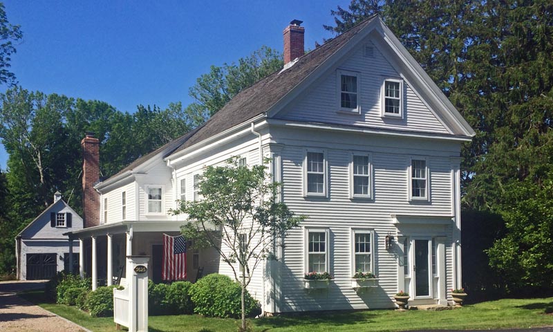 White house before the installation of historic house shutters.