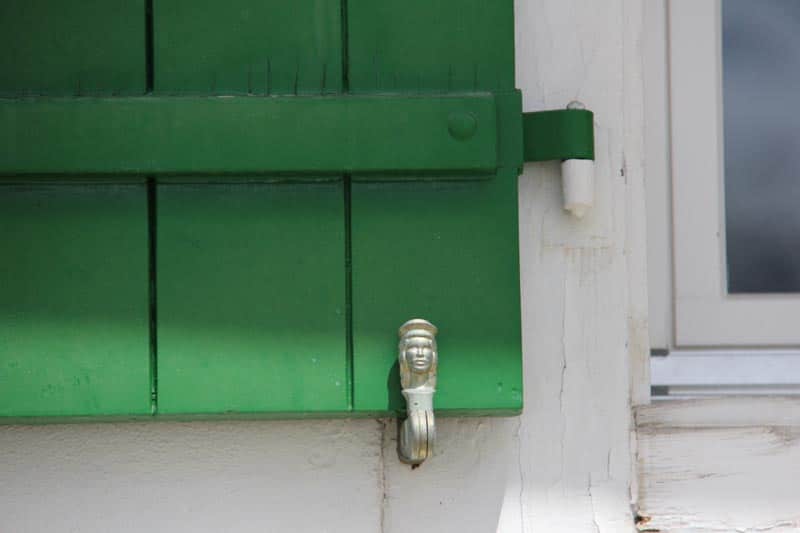 French lady shutter dog with green farmhouse shutter.