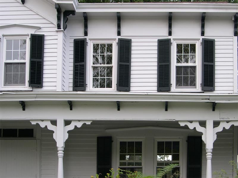 Historic wood farmhouse louvered panels installed on a white house.