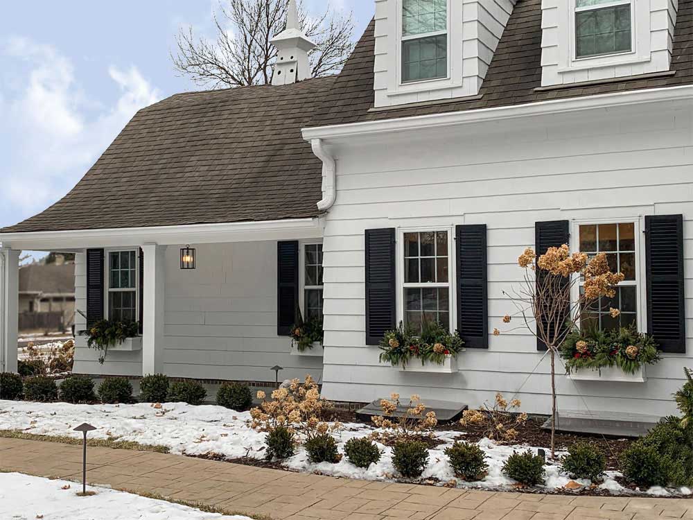 Black modern farmhouse shutters installed on white exterior siding.