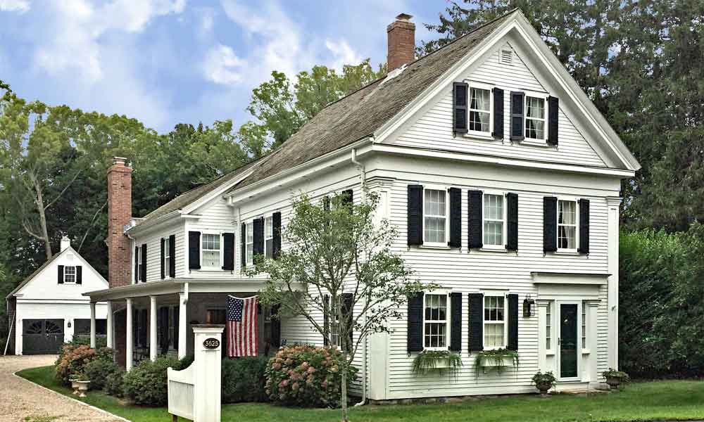 Historic house with black exterior shutters and functional hardware.