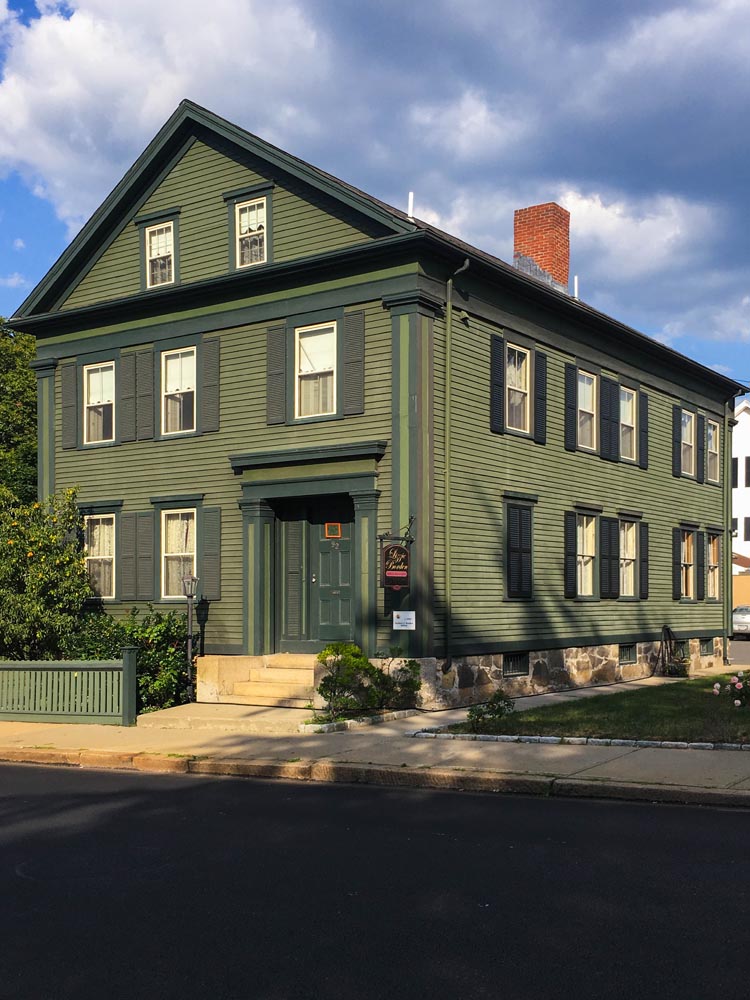 Lizzie Borden house with wood louvered green shutters.