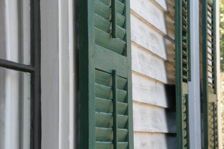 Exterior Green Shutters on a Green House Wood Louvered Exterior Green Shutters on a Green House Wood Louvered