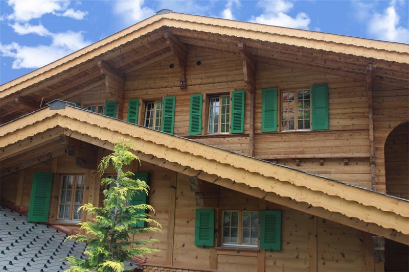 Closeup of Swiss Alpine home with green shutters