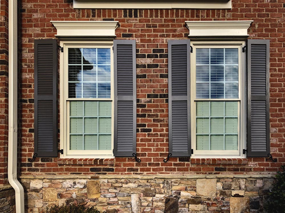 Install louvered exterior shutters on brick.