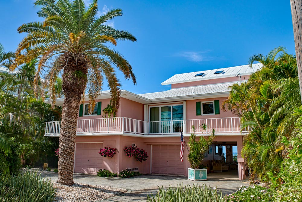 Pink Florida house with wood exterior shutters.