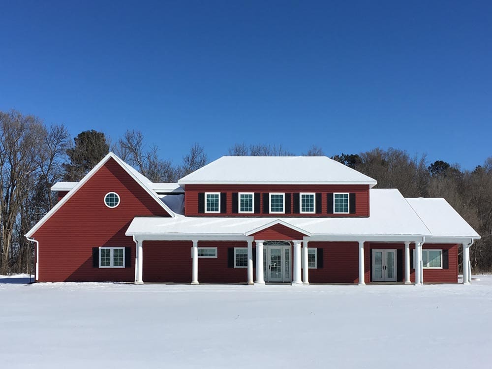 Window shutters to help with insulation on a red house.