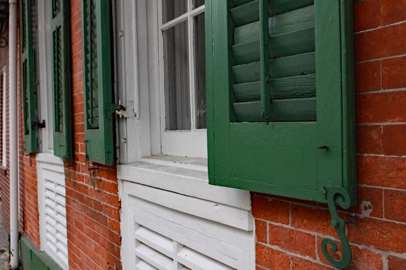 Exterior green shutters with movable louvers in New Orleans.