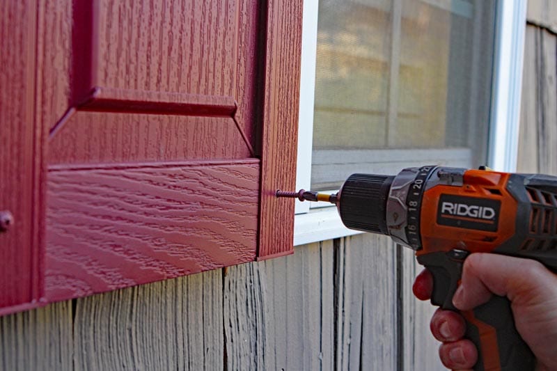 Install exterior vinyl shutters with screws and a drill.