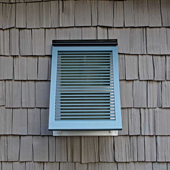Exterior Bahama shutter installed on a tropical window.