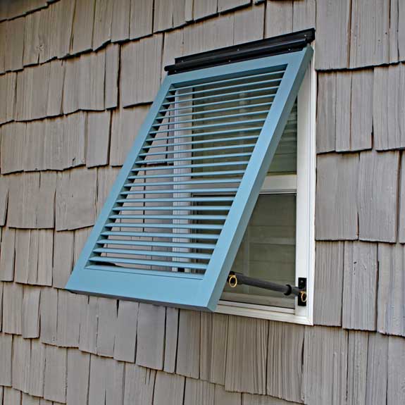 Outdoor Bahama shutters install on a coastal window.