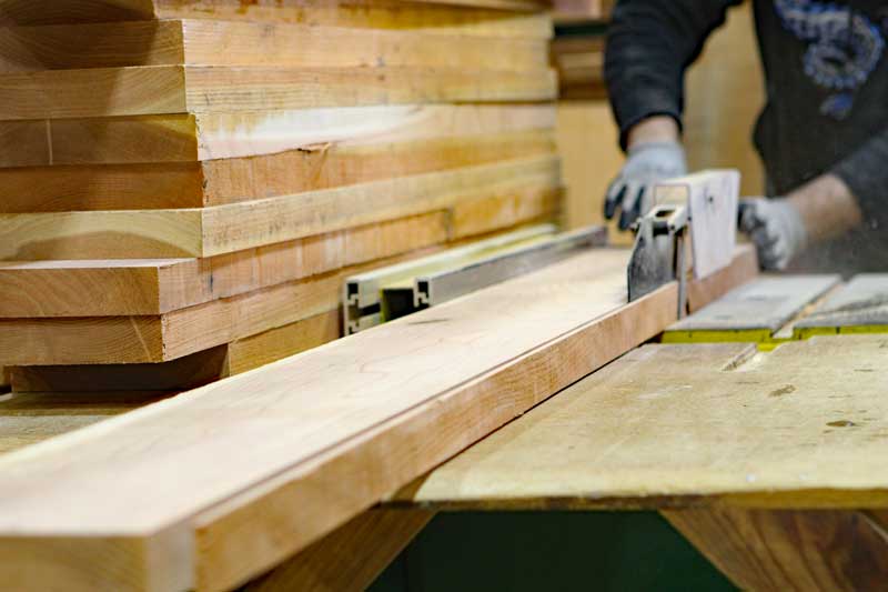 Sawing wood to build exterior shutters.