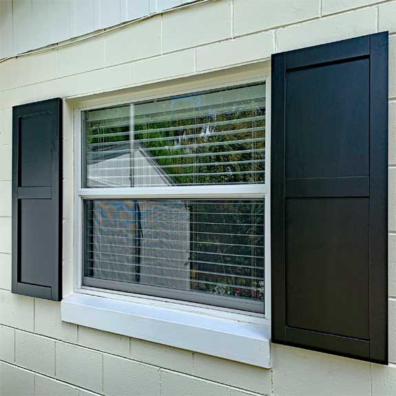 Black exterior composite solid flat panel shutters.