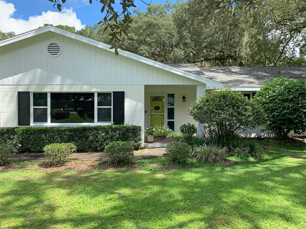 White house with black flat panel exterior shutters.