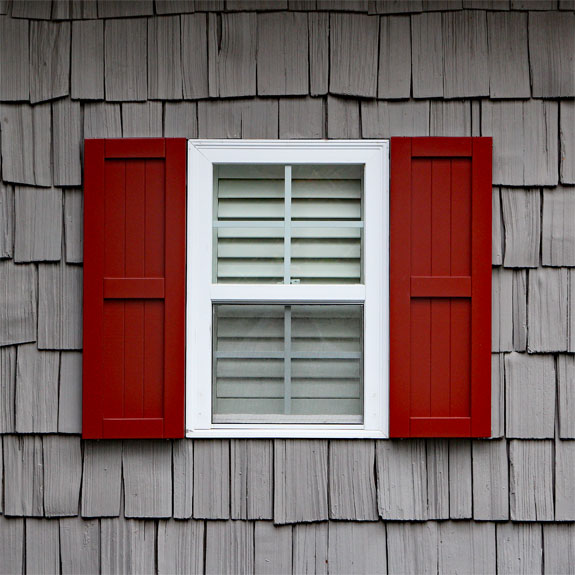 Red composite shaker style exterior shutters.