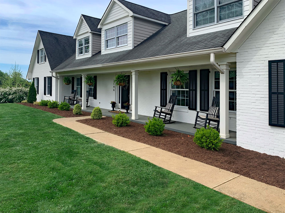 Black exterior shutters installed on a white farmhouse.