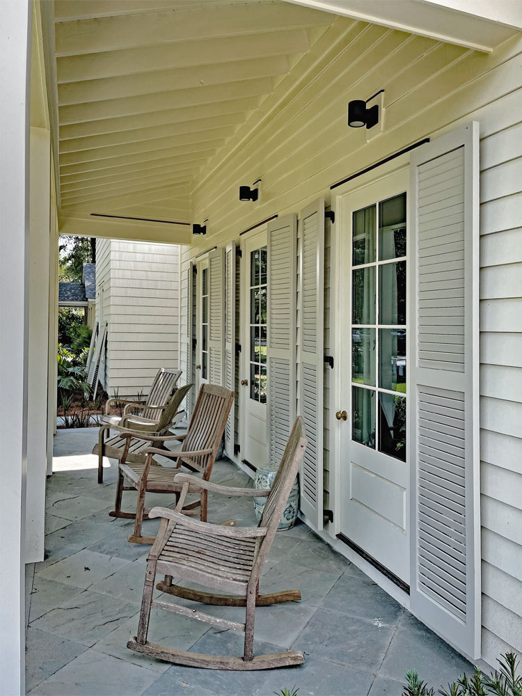 Outdoor front porch with rocking chairs and exterior shutters.