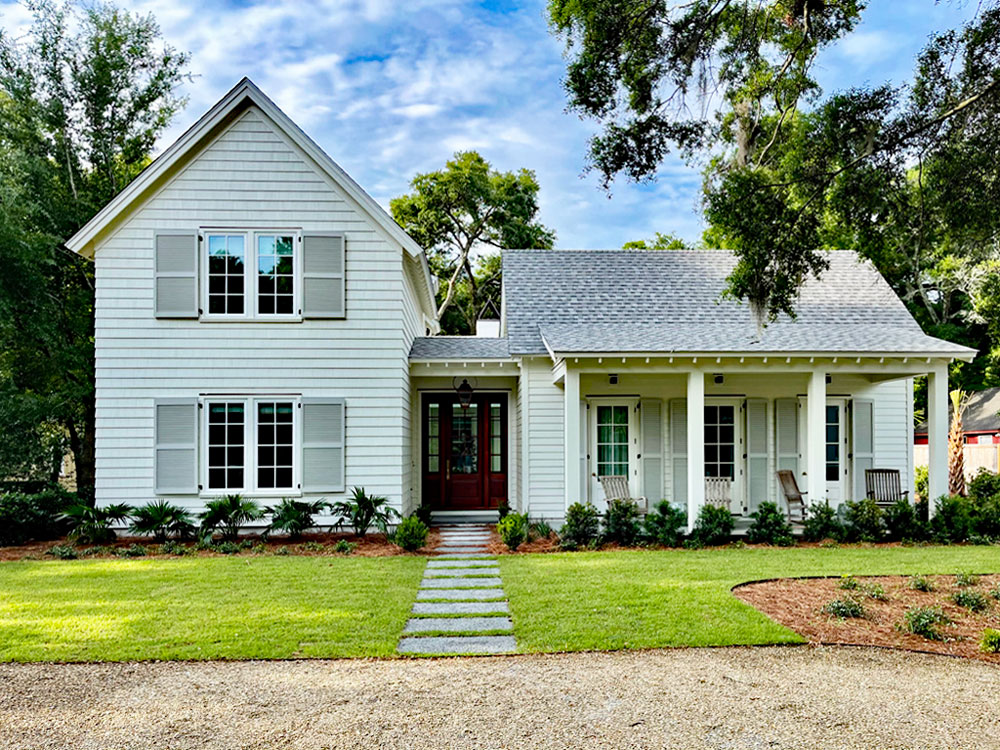 White house with beautiful grey wood louvered shutters.