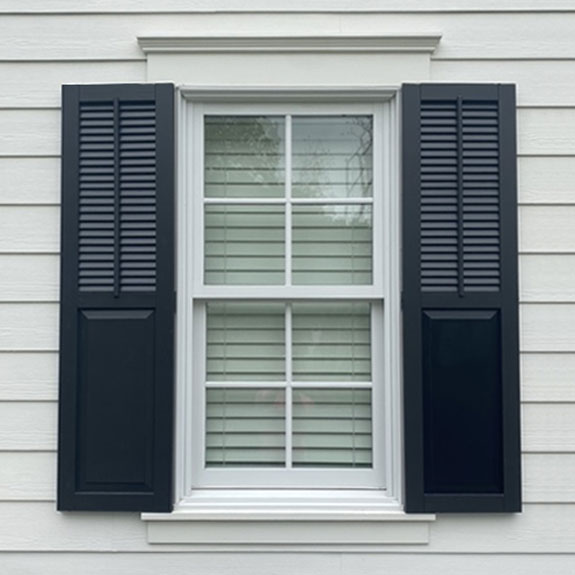 Black combo composite exterior window shutters.