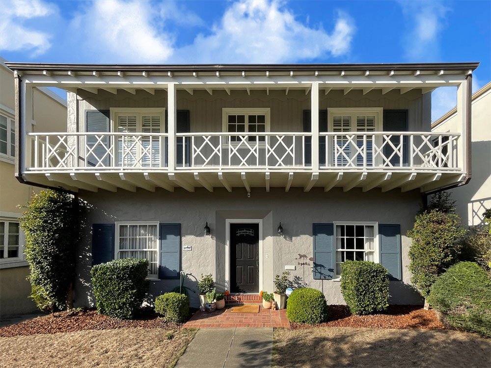 Exterior window shutters with louvers installed on a two-story house.