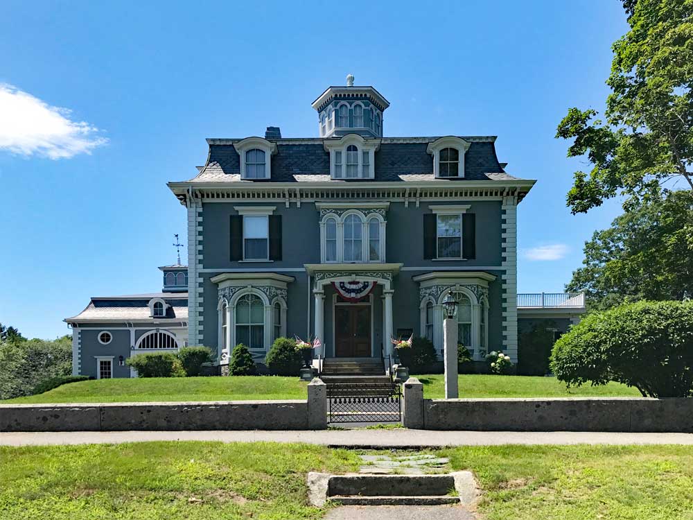 Second empire house with black exterior shutters.