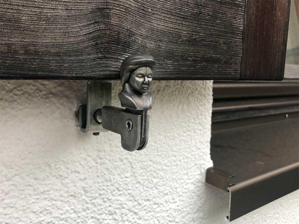 Silver shutter dog with the face of a noble person.