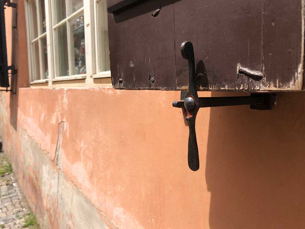 Swivel propeller-type shutter dog that extends to lock the shutter closed.