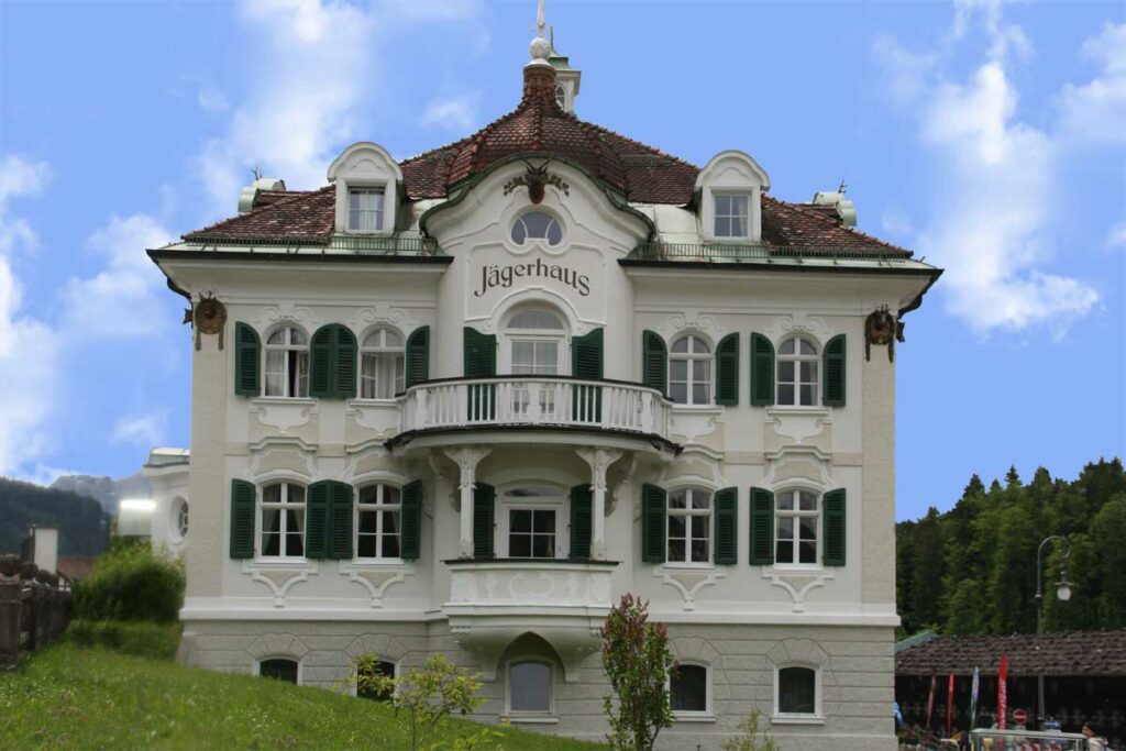 Large home in Germany with arch top louvered outdoor shutters.