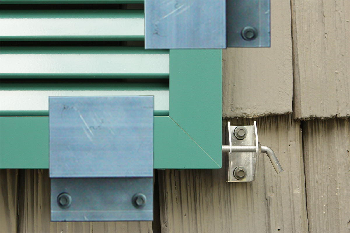 Aluminum bahama shutters locked down with z-clamps to secure from hurricanes.