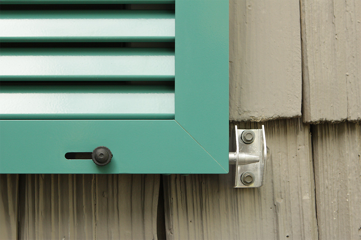 Aluminum bahama shutters locked down with pin latches to secure from hurricanes.