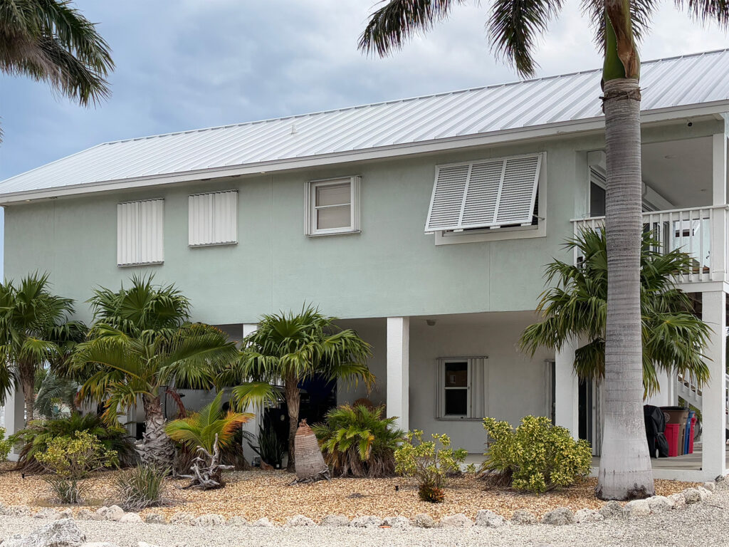 Accordion and aluminum bahama hurricane shutters installed on the same house.