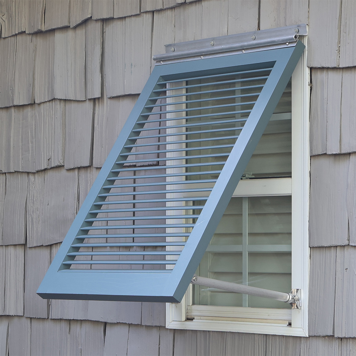 Side view of a wood Bahama shutter with fixed open louvers for exterior windows.