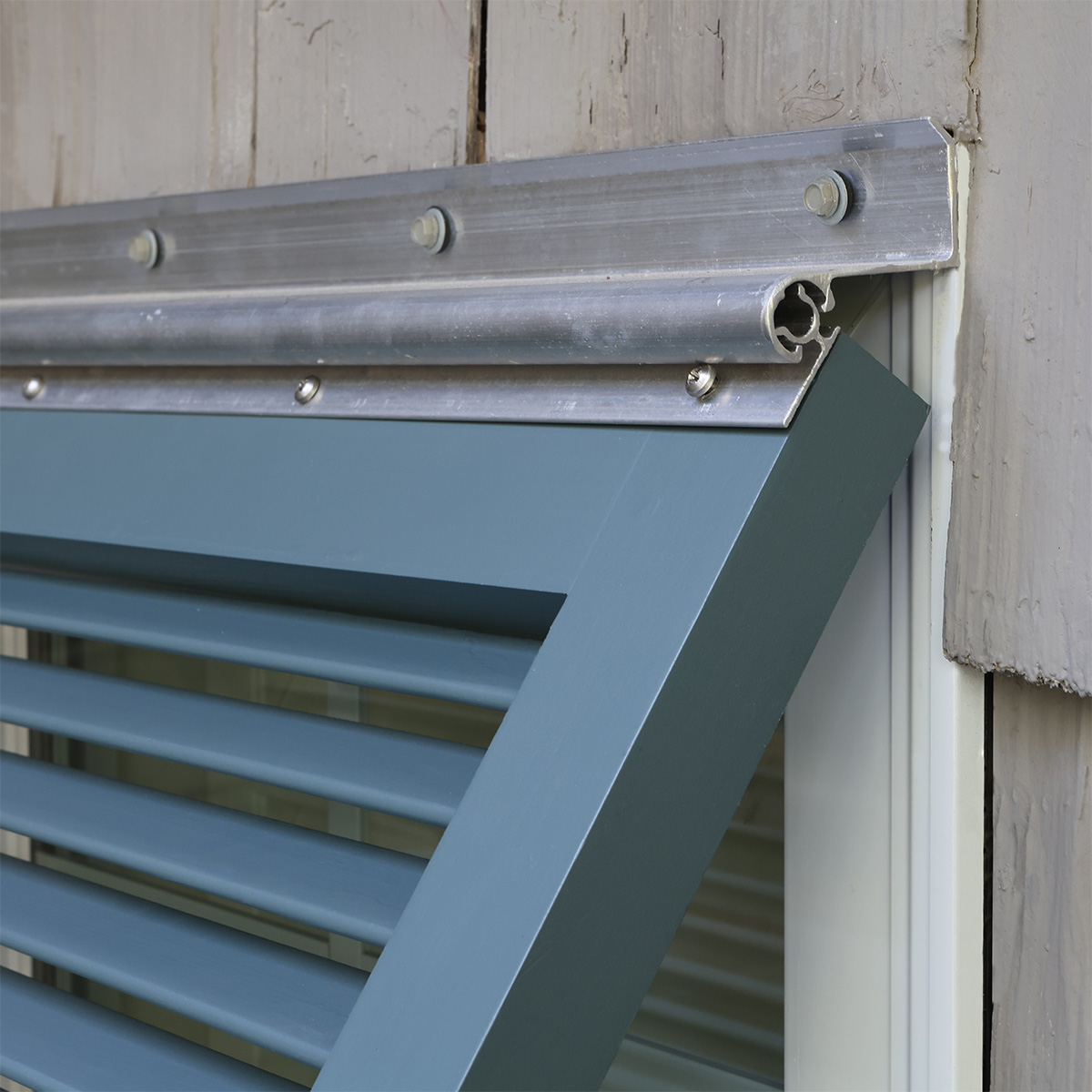 Top hinge of solid wood exterior Bahama window shutter.
